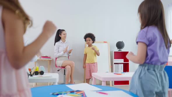 Caucasian beautiful woman teacher teaching a lesson to kid at school.