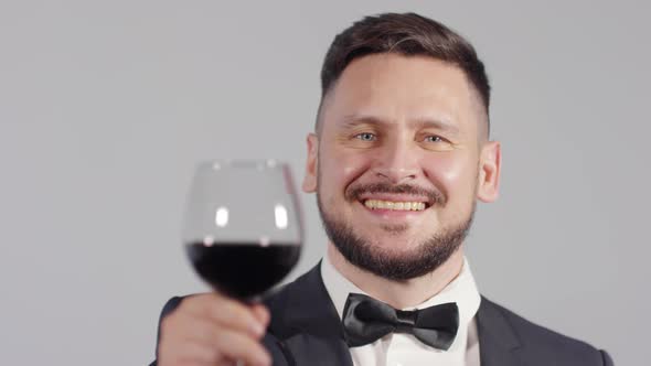 Portrait of Smartly Dressed Man Raising Wine Glass