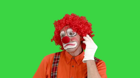Clown with Smartphone Making a Call on a Green Screen Chroma Key