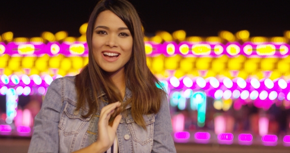 Smiling Young Woman at a Colorful Fairground