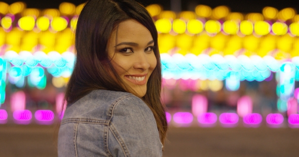 Smiling Young Woman at a Colorful Fairground