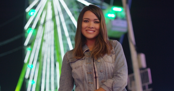 Pretty Happy Young Woman Relaxing at a Funfair