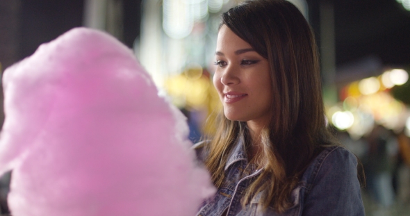 Laughing Young Woman Eating Pink Candy Floss