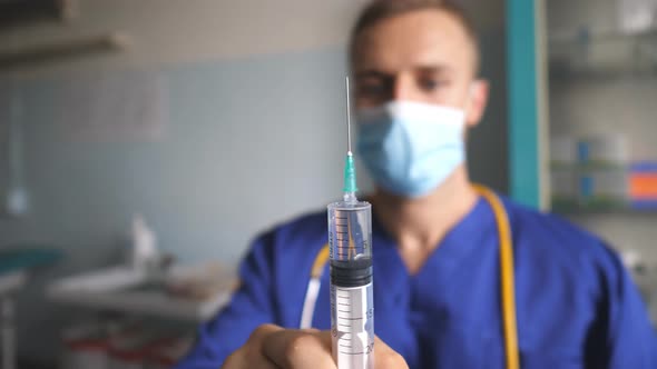 Portrait of Doctor in Protective Mask Pouring Liquid From Syringe