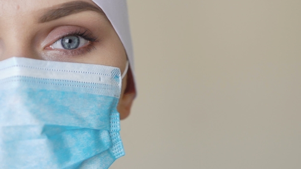 Female Medical Worker Wearing Face Mask Looking Into Camera