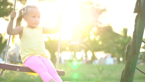 Pretty Little Girl on a Swing at the Playground