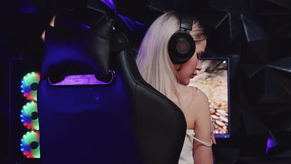 Blonde Sexy Gamer Girl Streamer Pulling Up the Strap From Her Top and Looks Into the Camera