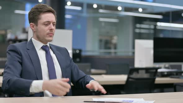 Businessman Celebrating Success While Reading Documents in Office