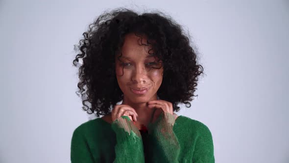 Laughing curly-haired woman posing at the camera