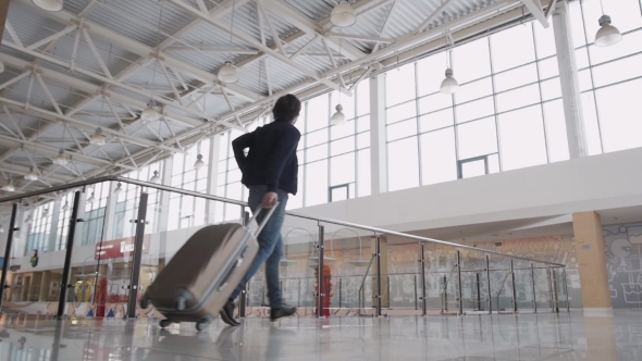 Unrecognizable Man with Suitcase Hurrying. Businessman Runing with Laggage in Airport Terminal or alt