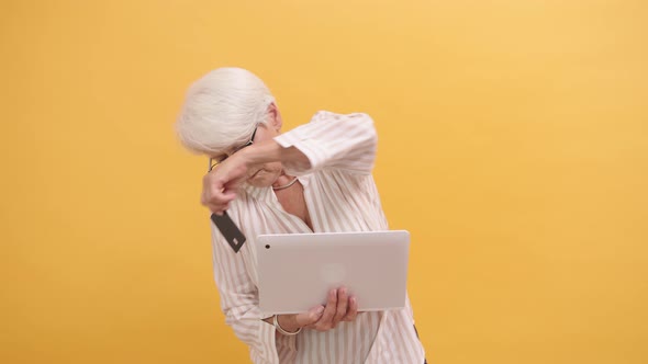 Senior Woman Trying To Insert Credit Card in the Laptop, Online Shopping 