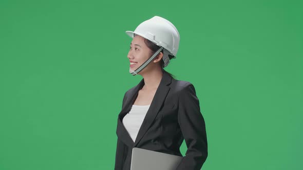 Asian Female Engineer With Laptop Looking Around And Shaking Her Head In The Green Screen Studio