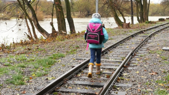 Back View of the Girl Going Along the Railway. First Grader Goes By Rail Sleepers