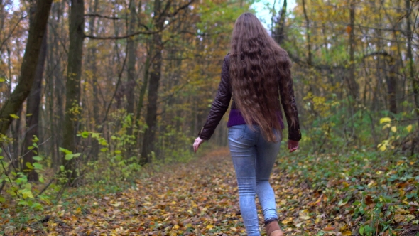Young, Beautiful Woman with Long Hair Walking in the Autumn Forest