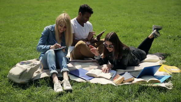 Threesome Students Studying on Campus Lawn.