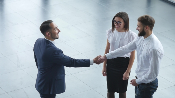 Top View of Young Male Consultant and Buyers Signing Contract for New Car in Auto Show. Concept for