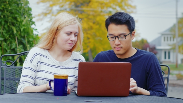 Two Young Multiethnic Friends Working with Laptop