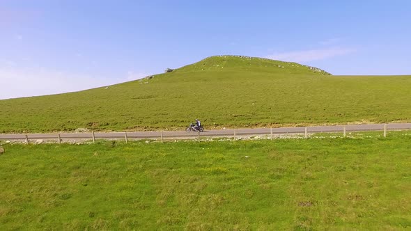 Motorcyclist driving his motorbike on the mountain road in the mountain country side.