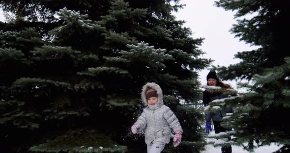 Cheerful Smiling Children Play Snowballs on the Street Run and Throw Snowballs Slow Motion