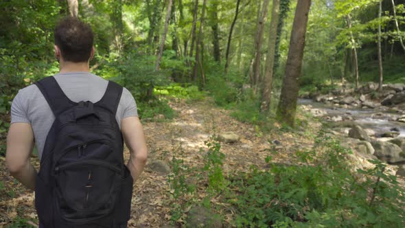 Young man in nature is walking in the forest.