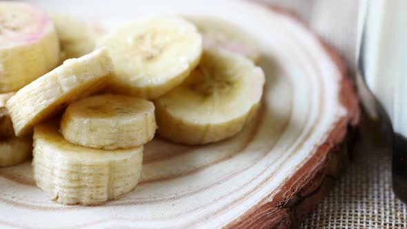 Close Up of Slice of Banana Glass of Milk on Table