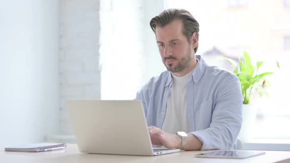 Young Man Showing Thumbs Up While Using Laptop