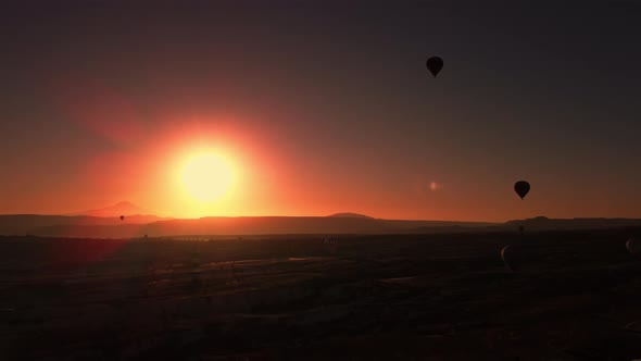 Breathtaking Golden Sunrise Over Mountain Range Near Cappadocia Terrain and Balloons in Sky