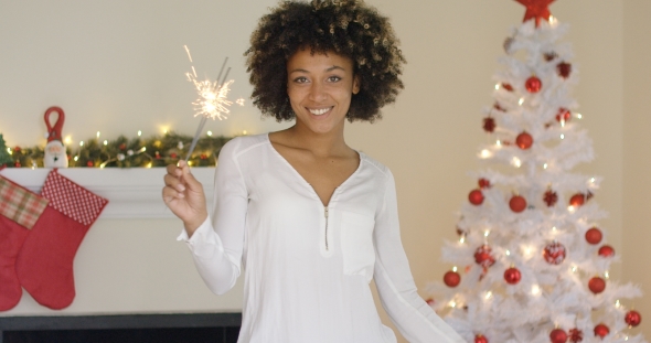 Pretty Young Woman Burning a Christmas Sparkler