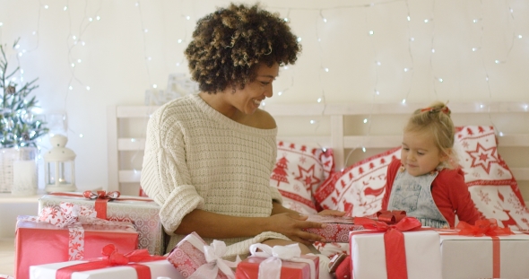 Mother Showing Female Child Christmas Gifts