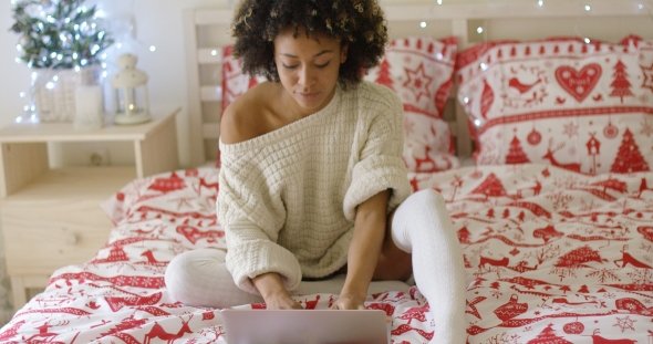 Woman in Oversized Sweater on Bed Using Laptop