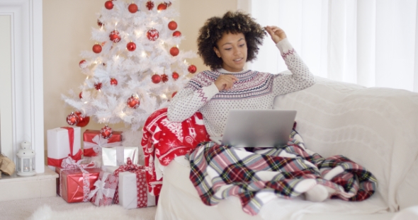 Young Woman Relaxing in Front of a Christmas Tree