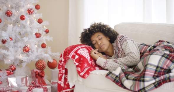 Woman Sleeping on Couch Beside Christmas Tree