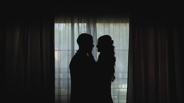 Silhouette of Newlywed Loving Couple Standing Near the Window