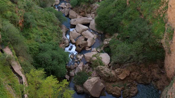 Overhead View Looking Down At Valley With River Running Through Large Boulders In Ronda. Tilt Up