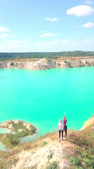 Two girls are sitting on the peak of the mountain on the chalk quarries