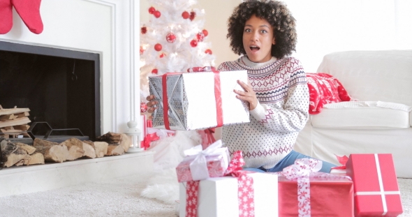 Surprised Woman Holding a Large Christmas Gift