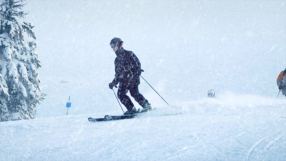 Skiers on Slope in Snowfall