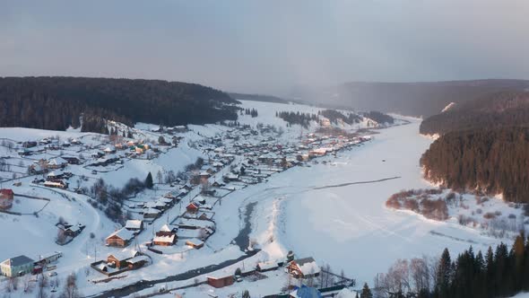 Aerial View of the Village at Sunset in Winter with Bright Sun
