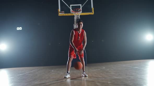 Slow Motion Asian Basketball Player Hits the Ball Off the Floor and Warms Up Before the Game