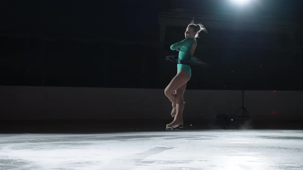 Young Girl Figure Skater is Doing Double Jump on Ice Rink Training and Warming Up Before Performance