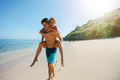 Man carrying girlfriend on his back along the beach - PhotoDune Item for Sale