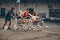 Young friends racing with shopping carts - PhotoDune Item for Sale