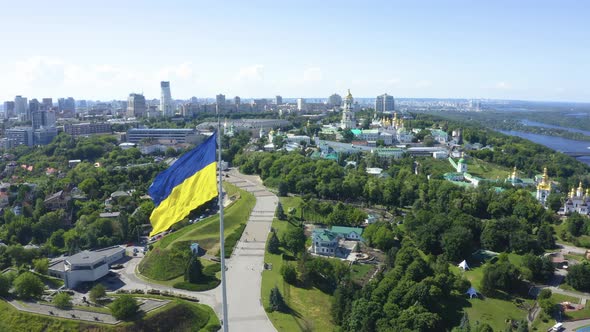 Aerial View of the Ukrainian Flag Waving in the Wind Against the City of Kyiv