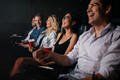 Young people in theater watching movie and smiling - PhotoDune Item for Sale
