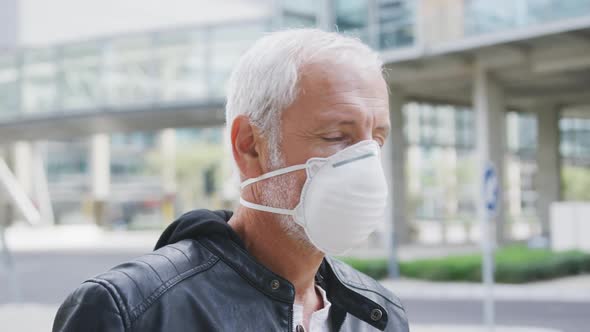 Caucasian man out and about in the street wearing on a face mask against coronavirus