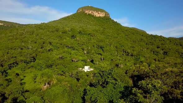 Aerial rising up and flying towards a large mesa surrounded by a dense forest in the Tocantins regio