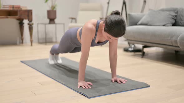Tired Indian Woman Doing Pushups on Yoga Mat at Home