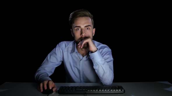 Man Excitedly Looking at a Computer Monitor. Dark Studio