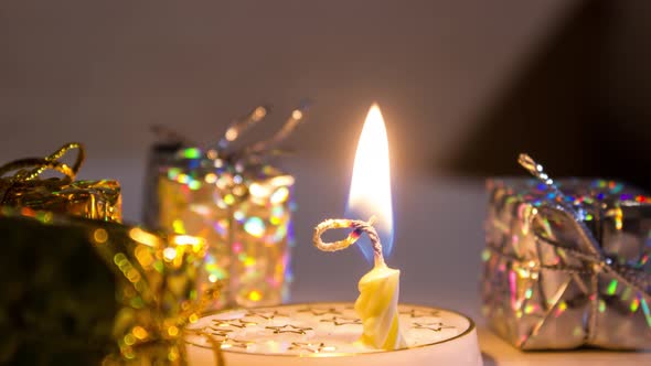 Candle Burns in Timelapse in Front of the Gifts