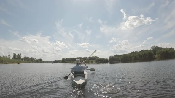 Backside View of a Couple Sailing on Canoe